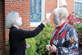 Press photo/Jake Browning - Volunteer Susie Ledford checks Faye Lansdell’s temperature before she goes into the service at First United Methodist Church on Sunday morning, Oct. 25.