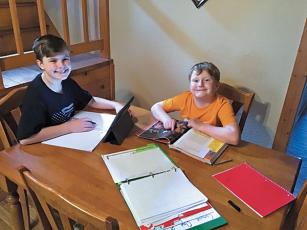 Press photo/Jake Browning - Sixth grader Ethan Johnson and second grader Bradley Johnson work on assignments for the Macon Virtual Academy.