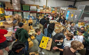 Photo courtesy of Melissa Ward - Panther track and field packs food boxes for CareNet at a team community service project Jan. 17. 
