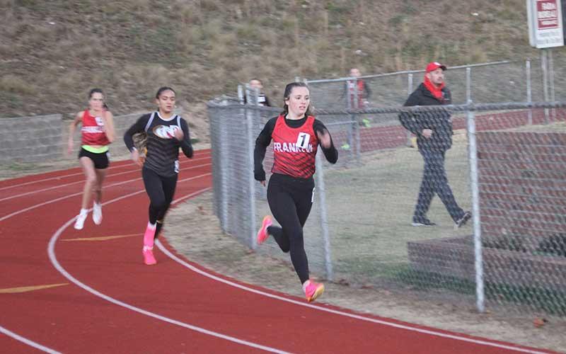 Press photo/Will Woolever - Senior Hope Smith (right) rounds the first turn in the women’s 500-meter dash at Swain Nov. 29. Smith won the event with a time of 1:20.16 and qualified for the 3A state meet in Winston-Salem Feb. 10.