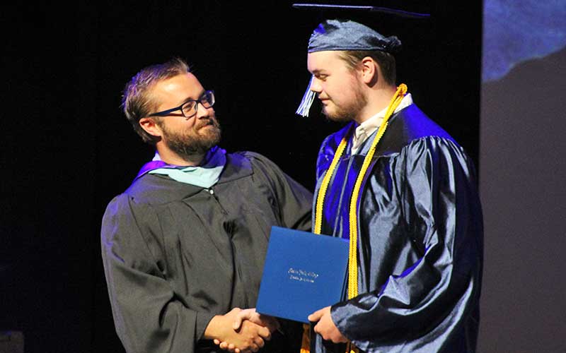 Press photo/Shelby Powell - Macon Early College student Kaden Marr accepts his diploma from principal Caleb Parham. Marr earned an Associate in Arts and a Criminal Justice Technology Certificate and will attend Western Carolina University. See more MEC graduation photos on Page A3 and on The Franklin Press Facebook page.