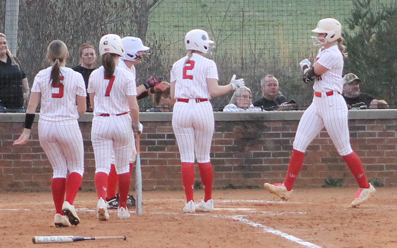 All-Conference selections (from left) Alyssa Awtrey, Chloe Lambert, Suzanna Cabe and Ashlyn McConnell mob Kendall Rumans at home plate after Rumans’ two-run homer versus Murphy March 4. (Press file photo)