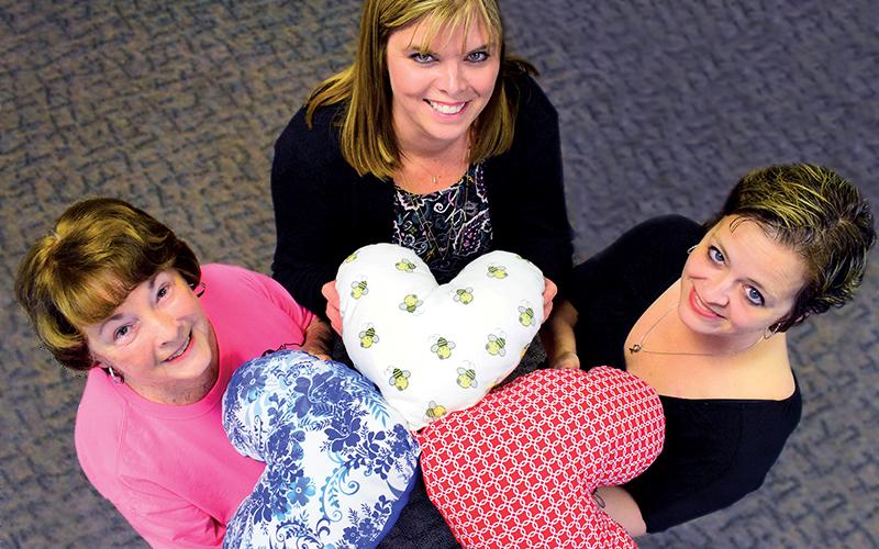 Press photo/Linda Mathias  - Breast cancer survivors in Macon County are sewing heart shaped drainage tube pillows for current patients. From left: Rita McElroy, Lori Smith, Gwen Bradley-Stanfield.