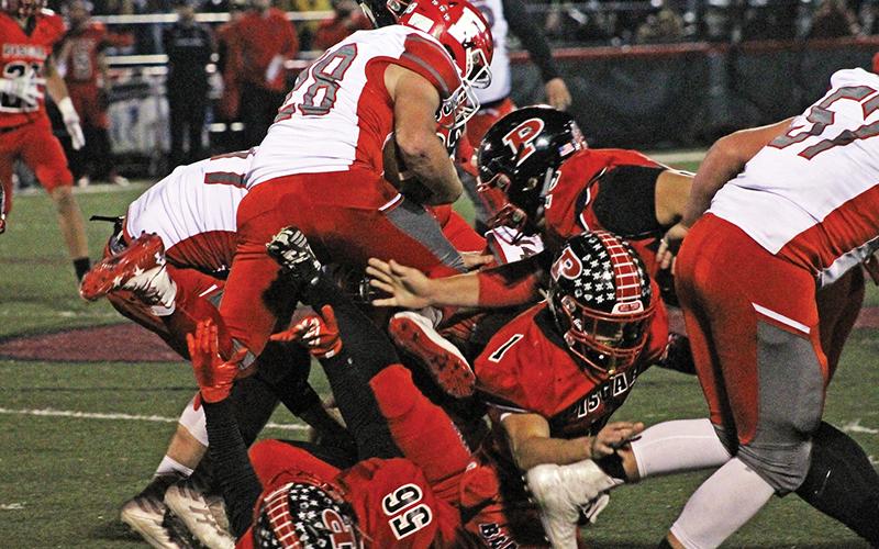 Press photo/Andy Scheidler - Franklin junior Seth Price leaps over a pile of players during last week’s game at Pisgah. It was the junior’s first game action since he broke his collarbone in September.