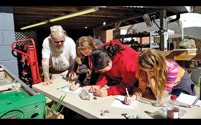 BSA scouts Anna Williamson, Trishelle Tyndell and Rose Callenback get a geology lesson with Troop 4200.