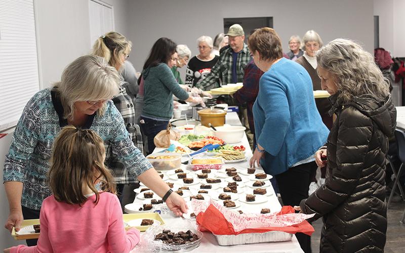 Press photo/Jake Browning Volunteers from Franklin First Assembly fix plates to serve to attendees at the Serving Spoon Dinner the week before Christmas.