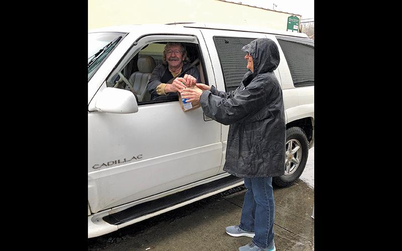 Eddie Leatherwood picks up breakfast at The Normandie on a rainy Monday morning. Servers are Valinda Daves and Shelly Conner (not pictured).