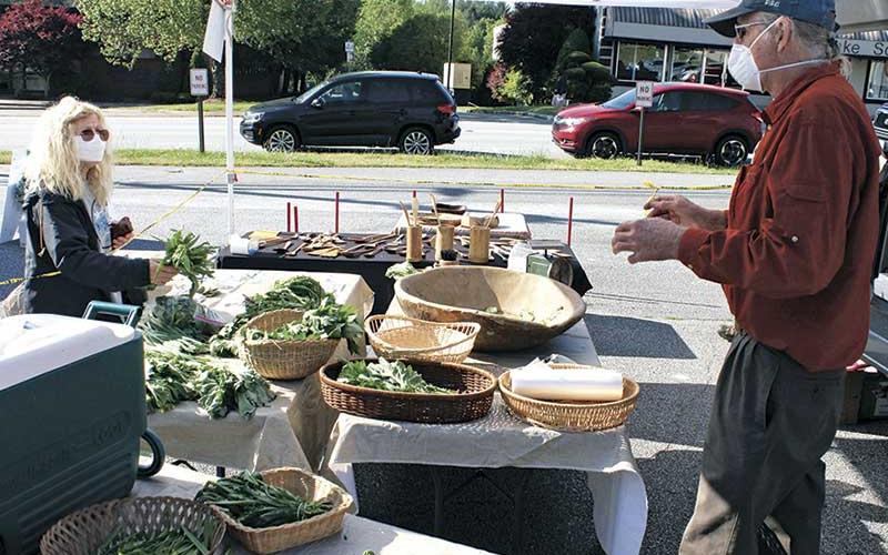 Press photo/Andy Scheidler - Vendor Paul Chew talks to customer Debi Gedling while she purchases produce at the Franklin Farmers Tailgate Market.