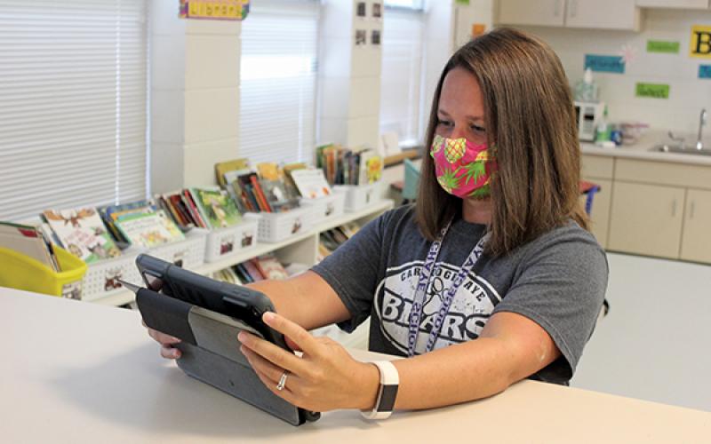 Press photo/Jake Browning Cartoogechaye Elementary School third-grade teacher Katie Kennedy sets up a tablet in preparation for her students’ return on Monday.