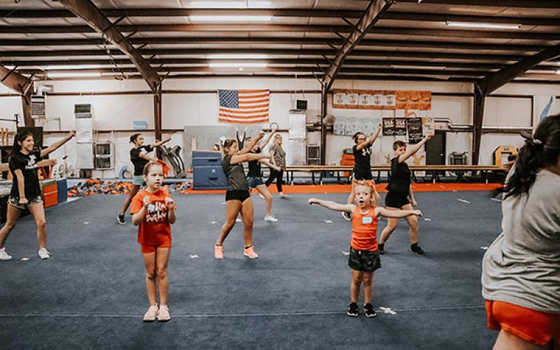 Photo/Alyssa Burk - Ruby Red cheerleaders practice a routine inside New Vision Training Center in Franklin.