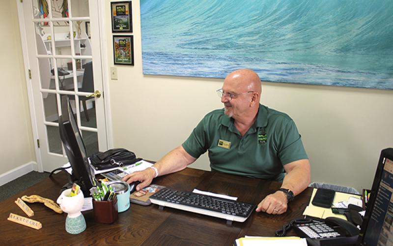 press photo/Will Woolever - Bald Head Realty owner/broker John Becker checks the company website in his Franklin office.