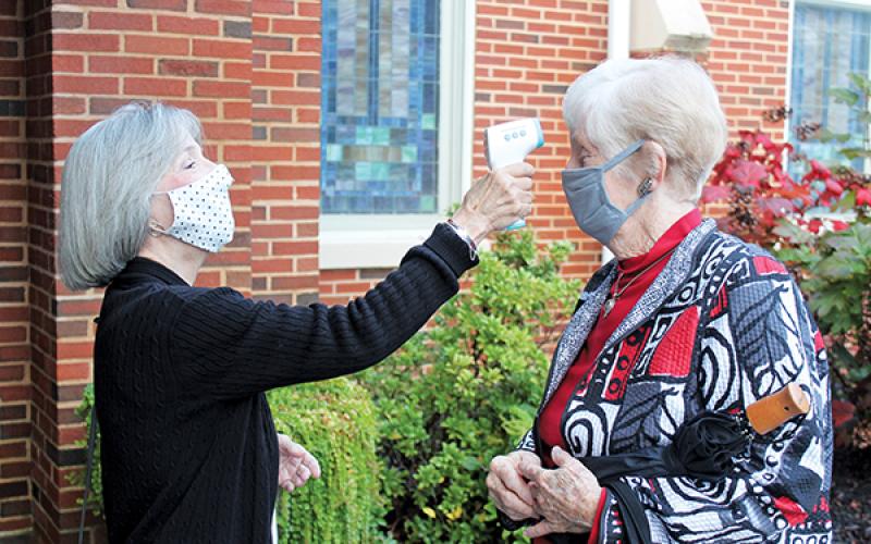 Press photo/Jake Browning - Volunteer Susie Ledford checks Faye Lansdell’s temperature before she goes into the service at First United Methodist Church on Sunday morning, Oct. 25.