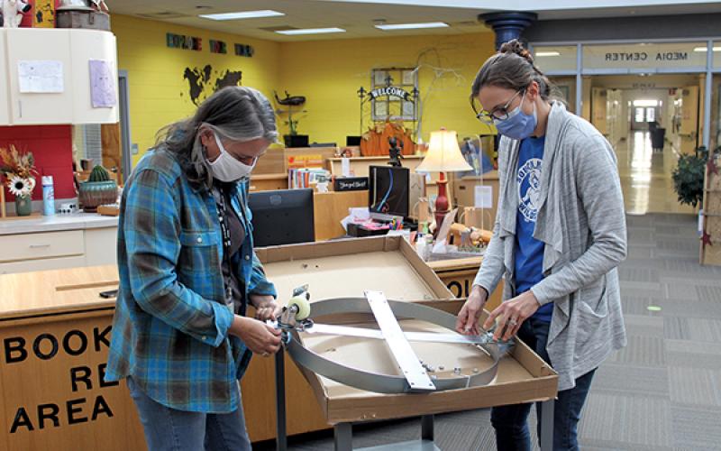Press photo/Jake Browning - Teachers Jennifer Love and Kelsea Youmans assemble a rolling base that makes a Tower Garden mobile.