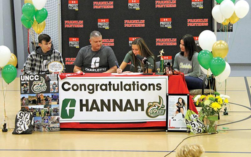 Press Photo/Will Woolever - Senior track and field star Hannah Angel (center right) signs her official offer letter from UNC Charlotte while her brother, Phillip (left); dad, Jeremy; and mom, Jennifer, look on.