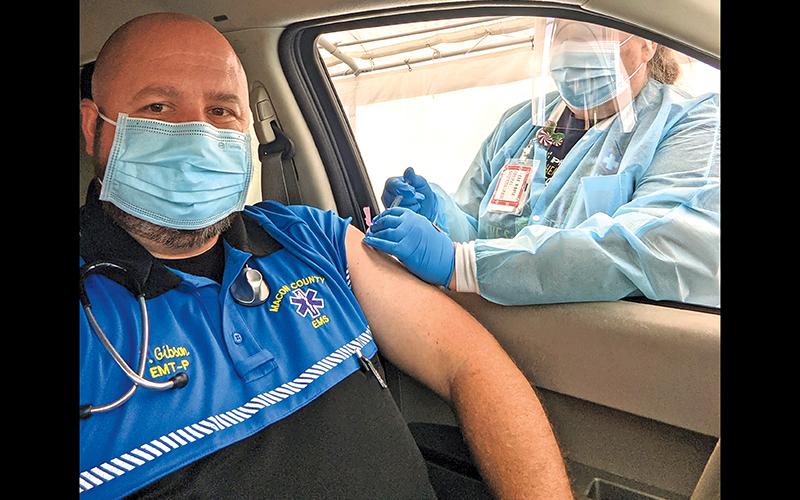 Photo/Macon County Public Health Macon - County EMT Joey Gibson receives his first dose of the Moderna COVID-19 vaccine from Jennifer Garrett, the county’s director of nursing.