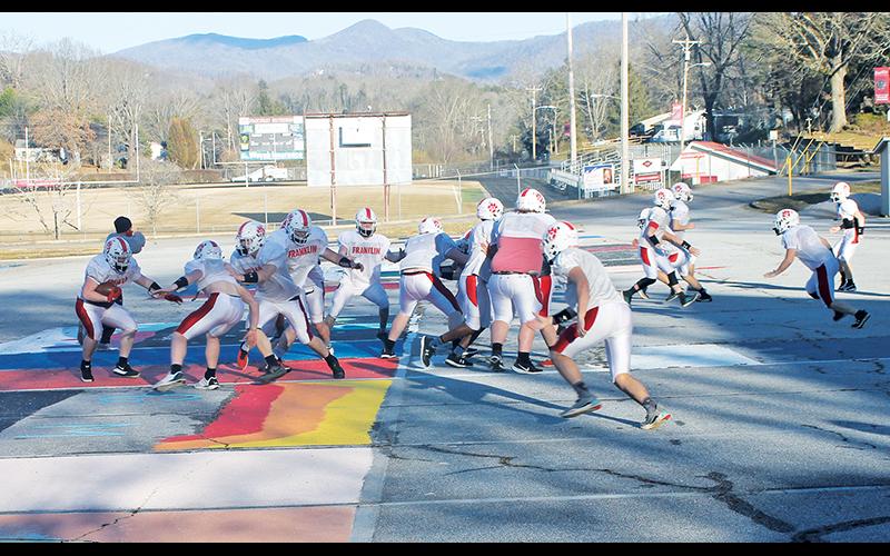 Press Photo/Will Woolever - Franklin football player Gabe Nickerson carries the ball in a practice drill Feb. 22. The Panthers held practice in the school’s parking lot due to muddy fields.