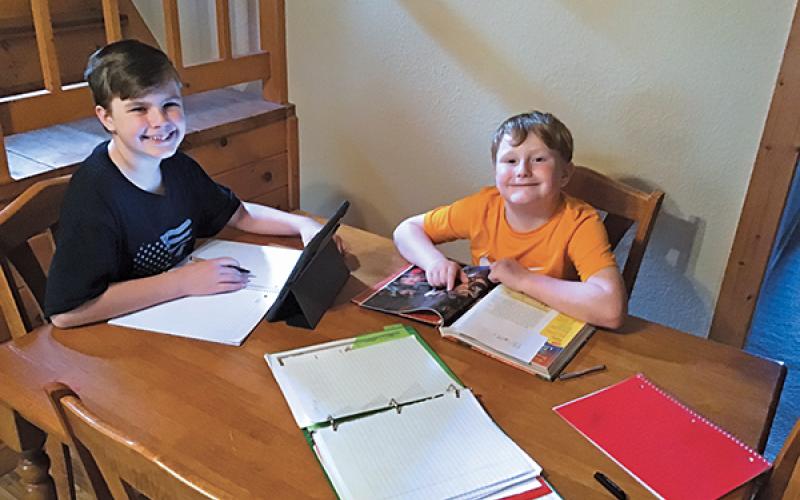 Press photo/Jake Browning - Sixth grader Ethan Johnson and second grader Bradley Johnson work on assignments for the Macon Virtual Academy.