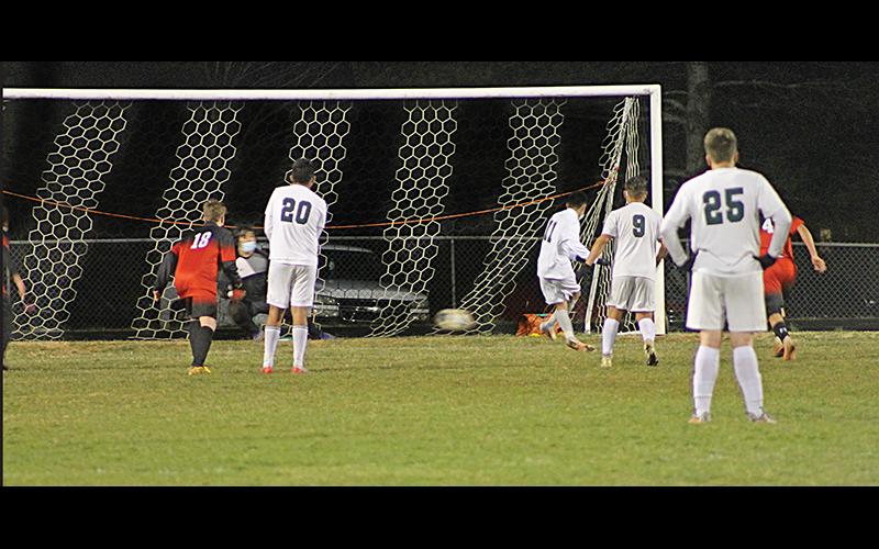 Press Photo/Will Woolever - Franklin goalkeeper Isaac Jennings dives for a penalty kick against East Henderson while freshman midfielder Jaydon Pevia looks on. Jennings saved the shot to give Franklin a 1-0 win over the Eagles.