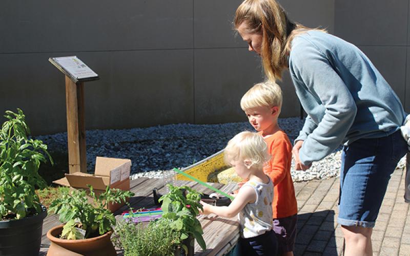Press photo/Jake Browning - Aeven Tucker, Callum Tucker and Morgan Price learn about making homemade rain gauges during “Sowing Seeds for Our Table” at the Macon County Public Library.