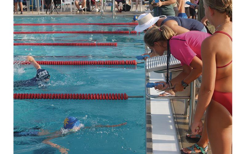 Press Photo/Will Woolever - F.A.S.T. timers watch a last-second finish between two swimmers in the boys’ 9-10 50-yard freestyle.
