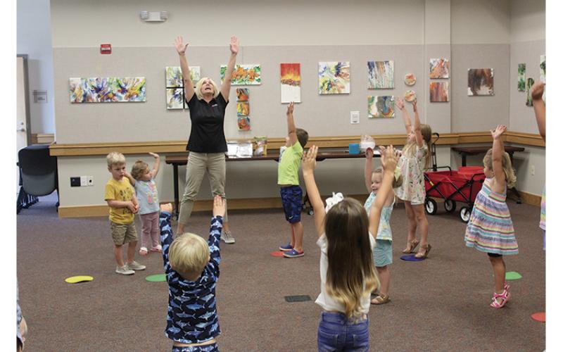 Press photo/Jake Browning - Kim Terrell leads her class at the library in a few warmup exercises before they start on the day’s nutrition lesson.