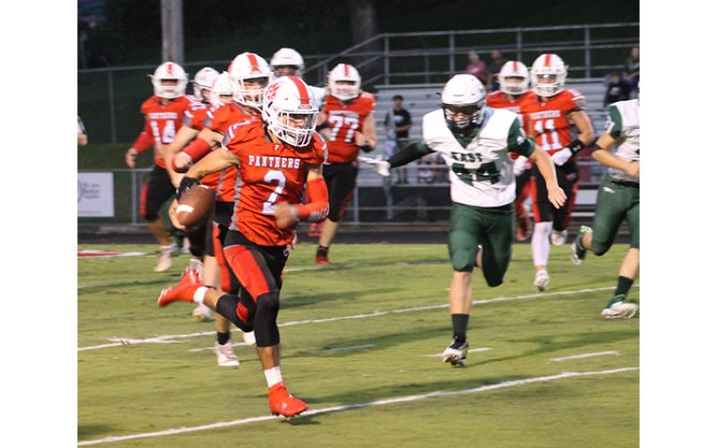 Press Photo/Will Woolever - Senior quarterback Chris McGuire outruns East Henderson defenders in the first quarter of their Sept. 17 blowout win. McGuire would score a 41-yard touchdown on the play.