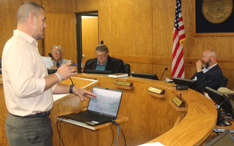 Press photo/Jake Browning - County Manager Derek Roland reviews the new pay scale for county employees at the Oct. 12 meeting.