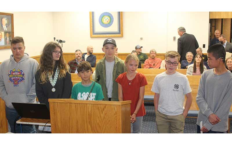 Press photo/Jake Browning - 4H Club members speak to the county commissioners about their experience with the club and their recent success shooting at the state level. From Left: Jackson Cabe, Lily Powell, Marco Morales, Wesley Merritt, Charlie Merritt, Ryland Angel, Matthew Albers.