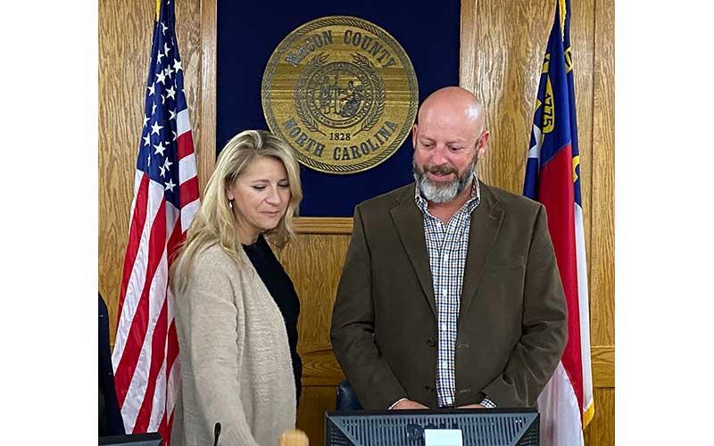 Press photo/Rachel Hoskins - Jim Tate’s wife, Allison, joined him at the podium to adjourn the Nov. 8 meeting of the Macon County Board of Commissioners. This was Jim Tate’s last official meeting as a board member and chairman.