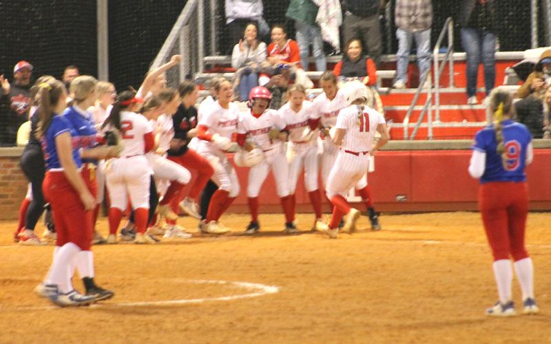 Press photo/Will Woolever Freshman pitcher/third baseman Kendall Rumans (right) crosses the plate after her walk-off grand slam over West Henderson March 31.