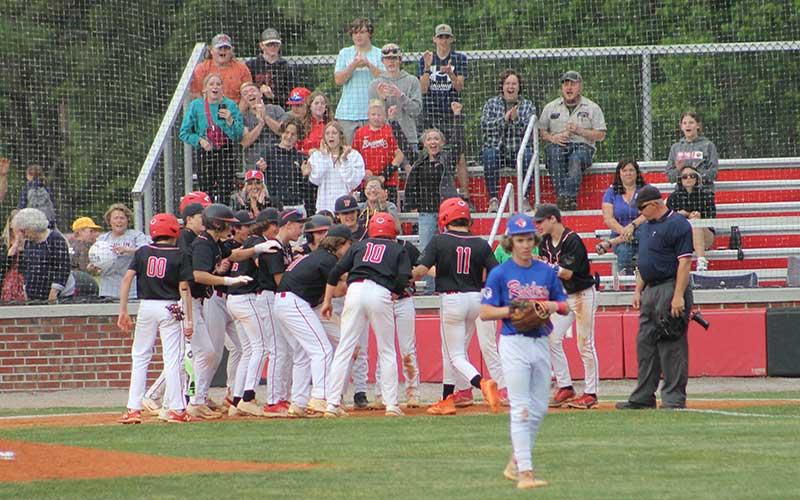 Press photo/Will Woolever - Eighth-grade shortstop/pitcher Will Rauers (#11) is mobbed by teammates at home plate after his three-run homer in the Blue Ridge Athletic Conference Championship.