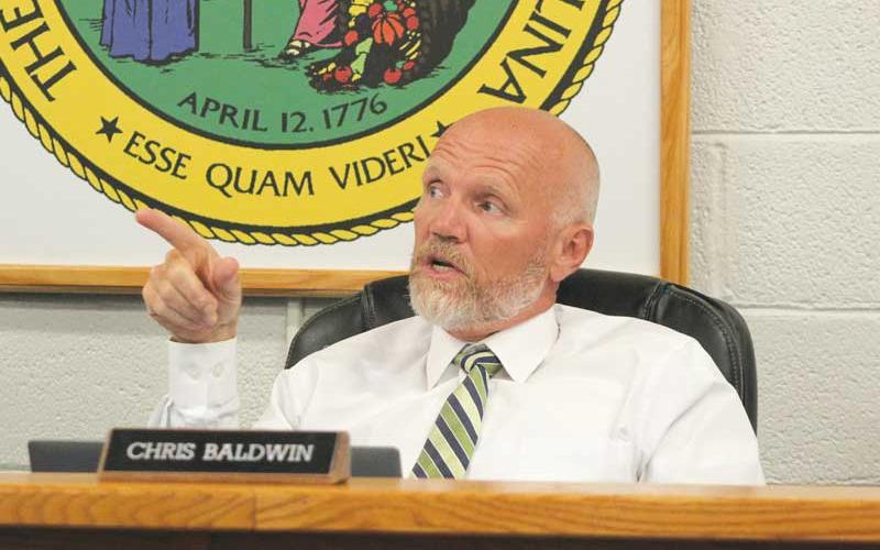 Press photo/Thomas Sherrill - Dr. Chris Baldwin points to the screen to make a point during a discussion at the June 26 meeting of the Macon County Board of Education. The June meeting was the last for the retiring superintendent.