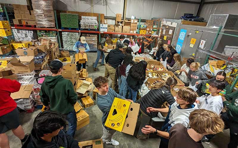 Photo courtesy of Melissa Ward - Panther track and field packs food boxes for CareNet at a team community service project Jan. 17.