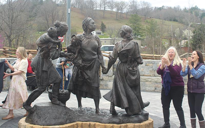 Press photo/Thomas Sherrill. The Sowing Seeds of the Future statue was officially unveiled Saturday during a ceremony on the banks of the Little Tennessee River, near where each of the three women depicted once lived. From left, pictured unveiling the statue is Women’s History Trail leadership team members Mary Polanski and Theresa Ramsey, plus Rebecca Stacey, a descendant of Na-Ka Rebecca Morris who is one of the women depicted in the statue.