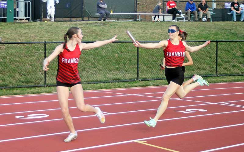 Press photo/Will Woolever - Freshman Audrey Pressley (left) takes the baton from senior Rylee Cassada in the women’s 4x200-meter relay at Western Carolina University March 7.