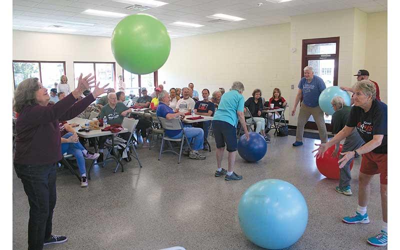 Press photo/Thomas Sherrill - Ginny Shelton (left) and Sue Feldkamp throw and roll exercise balls during a demonstration of a workout held each week at the community building.