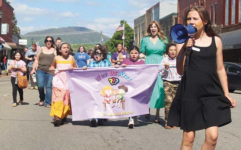 Press photo/Thomas Sherrill - Led by Gracie Parker, attendees of the second annual Youth Mental Health Rally in downtown Franklin march down Main Street. More photos from the rally will be posted on The Franklin Press Facebook page.