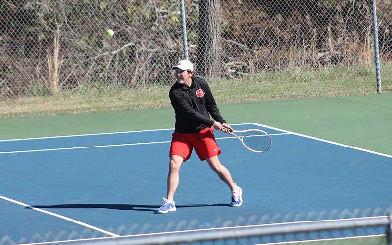Junior Eli Adams backhands a ball versus Pisgah at the Macon County Rec Park March 28 (Press photo/Will Woolever).