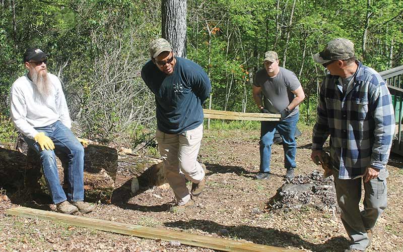 Press photo/Will Woolever - Special Operations Forces veterans Dominique Lewis (front) and Lucas Knighten (back) heft supplies for a raised-bed garden at Lewis’s home in Franklin recently. “Who says Army and Navy can’t work together?” Lewis joked.