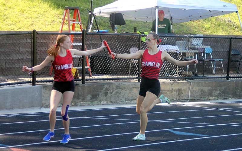 Right- Senior Rylee Cassada (right) hands the baton to sophomore Mindi Holbrooks in the women’s 4x400-meter relay. (Press photos/Will Woolever)