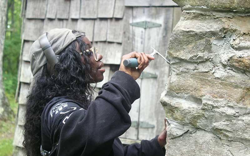 Press photo/Thomas Sherrill - Antanneya Belton puts some finishing touches on the Wilson Lick Ranger Station chimney.