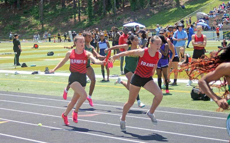 Press photo/Will Woolever - In a kind of figurative passing of the torch, senior Hope Smith (left) hands the baton to freshman Audrey Pressley in the 4x100-meter relay at the 3A West Regional May 11.