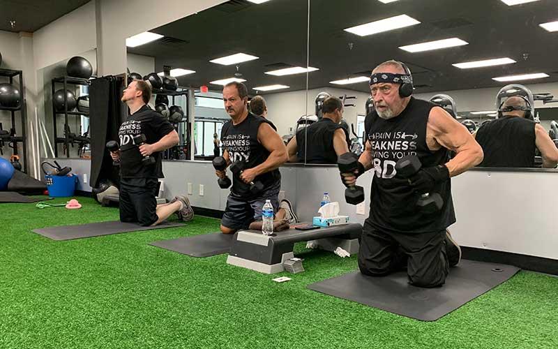 Press photo/Will Woolever - (From left) Stephen Drake, Johnny Lee and Dr. Rocky Battaglino pump iron at Franklin Health and Fitness recently. The trio meets twice a week to bust out nearly 2,000 pushups and flys.