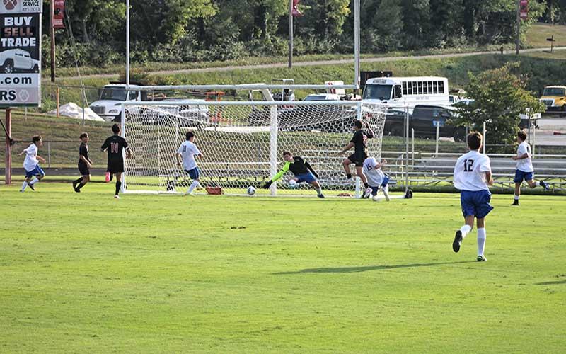 Press photo/Will Woolever - Junior forward Greg Karcher (wearing black) beats Highlands goalkeeper Chase Kenter in Franklin’s 11-2 season-opening rout Aug. 12.