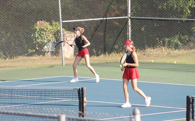 Abigail Angel forehands a ball versus Pisgah Aug. 26 while fellow senior Caroline Deal guards the net.