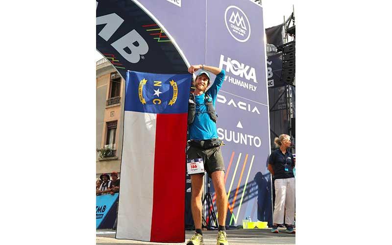 Photo courtesy of Rob Gasbarro, Outdoor 76 - Canyon Woodward unfurls a North Carolina flag at the Ultra Trail du Mont Blanc finish line in Chamonix, France last month. The Franklin native placed 23rd in the 110-mile race, widely regarded as the world’s most competitive trail ultramarathon.