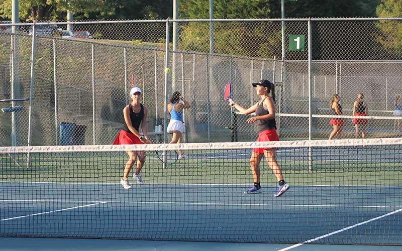 Press photo/Will Woolever - #1 doubles partners Maci Stork (left) and Kate Phillips look a ball in versus West Henderson Sept. 9.