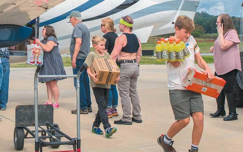 Photo/Bob Scott – Volunteers of all ages were on hand to help unload supplies flown in to the Macon County Airport.