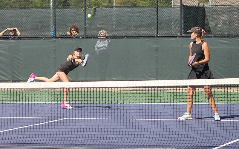 Press photo/Will Woolever - Senior Abigail Angel (left) hits a difficult backhand while her doubles partner Kate Phillips guards the net Oct. 9.