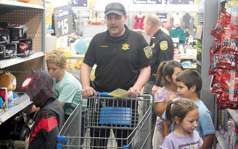 Press photo/Thomas Sherrill.  Jeff Dumford, a School Resource Officer with the Macon County Sheriff’s Office, was among the law enforcement officers and other emergency personnel shopping with kids for the annual Shop with a Cop on Dec. 19.